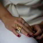 Fotografía de la mano de una modelo luciendo el anillo Ubud, una joya de diseño atemporal y elegante.