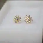 Pendientes Mare de oro sobre superficie blanca, vista media